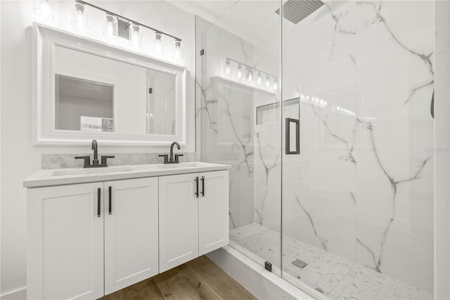 2554 Lake Ellen Cir, Tampa, FL 33618 - bathroom featuring a marble finish shower, double vanity, and wood finished floors