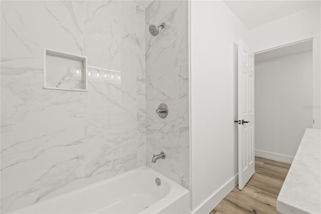 2554 Lake Ellen Cir, Tampa, FL 33618 - bathroom featuring washtub / shower combination, baseboards, and wood finished floors