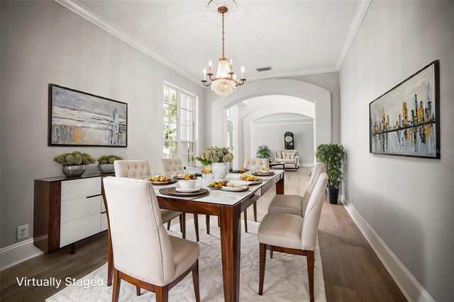 5160 Loquat Ct, Palm Harbor, FL 34685 - dining room featuring wood finished floors, arched walkways, a chandelier, ornamental molding, and baseboards