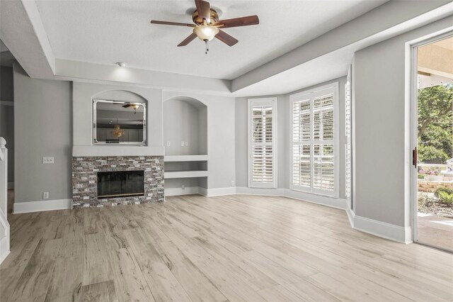 5160 Loquat Ct, Palm Harbor, FL 34685 - unfurnished living room featuring a ceiling fan, a fireplace, a raised ceiling, and wood finished floors