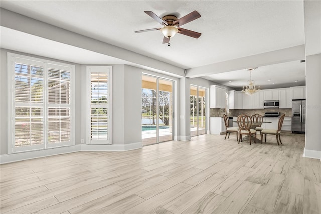 5160 Loquat Ct, Palm Harbor, FL 34685 - living area with a chandelier, baseboards, a ceiling fan, and light wood-type flooring