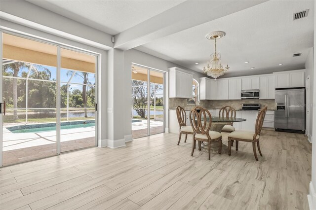 5160 Loquat Ct, Palm Harbor, FL 34685 - dining room featuring a chandelier, light wood finished floors, and baseboards
