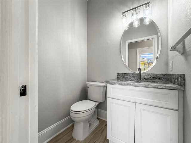 5160 Loquat Ct, Palm Harbor, FL 34685 - bathroom with toilet, vanity, wood finished floors, and baseboards