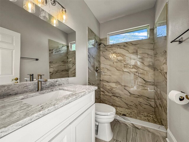 5160 Loquat Ct, Palm Harbor, FL 34685 - full bathroom with toilet, vanity, marble look tile flooring, and a marble finish shower