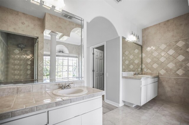 5160 Loquat Ct, Palm Harbor, FL 34685 - bathroom with two vanities, tile patterned flooring, baseboards, and tile walls
