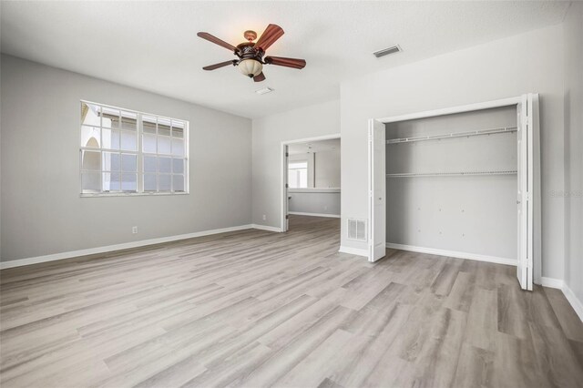 5160 Loquat Ct, Palm Harbor, FL 34685 - unfurnished bedroom with a closet, wood finished floors, baseboards, and a ceiling fan