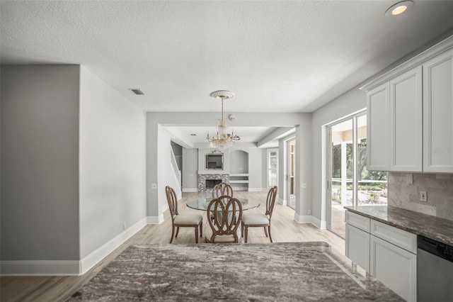 5160 Loquat Ct, Palm Harbor, FL 34685 - dining space featuring light wood finished floors, baseboards, a textured ceiling, a fireplace, and recessed lighting