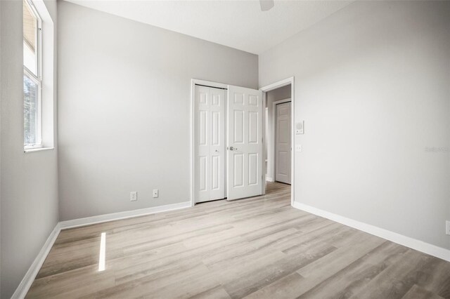 5160 Loquat Ct, Palm Harbor, FL 34685 - unfurnished bedroom with light wood-type flooring, baseboards, a closet, and a ceiling fan