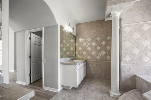 5160 Loquat Ct, Palm Harbor, FL 34685 - full bathroom with decorative columns, vanity, tile walls, baseboards, and wood finished floors