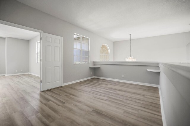 5160 Loquat Ct, Palm Harbor, FL 34685 - empty room featuring wood finished floors, baseboards, and a chandelier