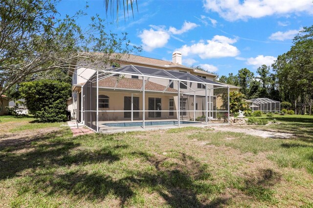 5160 Loquat Ct, Palm Harbor, FL 34685 - rear view of property featuring a chimney, a yard, an outdoor pool, and glass enclosure