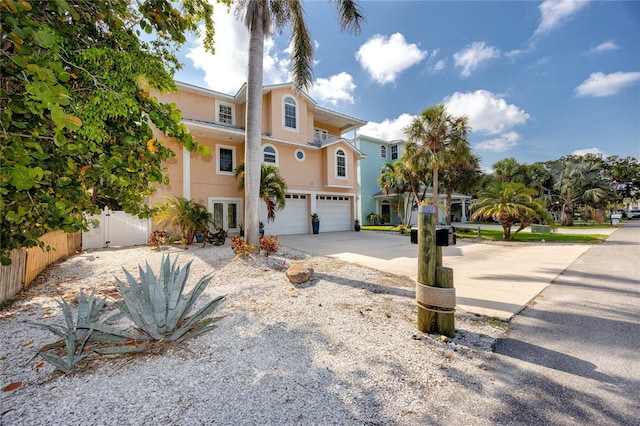 405 8th Ave N, Tierra Verde, FL 33715 - view of front of house featuring an attached garage, stucco siding, french doors, and driveway