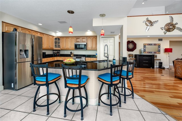 405 8th Ave N, Tierra Verde, FL 33715 - kitchen featuring appliances with stainless steel finishes, a sink, dark countertops, a kitchen bar, and glass insert cabinets