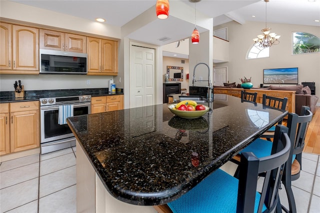 405 8th Ave N, Tierra Verde, FL 33715 - kitchen with appliances with stainless steel finishes, a sink, light tile patterned floors, light brown cabinets, and a breakfast bar
