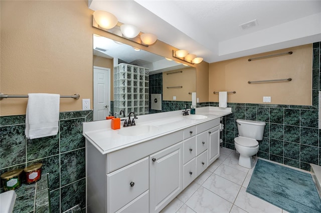 405 8th Ave N, Tierra Verde, FL 33715 - full bathroom with tile walls, double vanity, toilet, and wainscoting