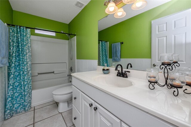 405 8th Ave N, Tierra Verde, FL 33715 - bathroom featuring vanity, toilet, shower / bath combination with curtain, a wainscoted wall, and tile patterned flooring