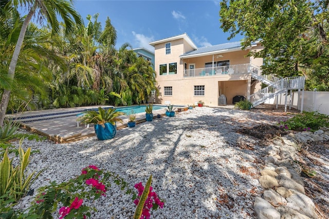 405 8th Ave N, Tierra Verde, FL 33715 - rear view of property featuring stucco siding, ceiling fan, stairway, an outdoor pool, and a patio