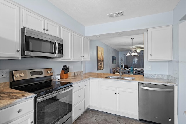 340 Causeway Blvd Unit 104, Dunedin, FL 34698 - kitchen featuring appliances with stainless steel finishes, a sink, white cabinetry, tile patterned floors, and recessed lighting