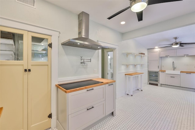 1825 2nd St S, Saint Petersburg, FL 33705 - kitchen featuring wall chimney range hood, ceiling fan, beverage cooler, a sink, and recessed lighting