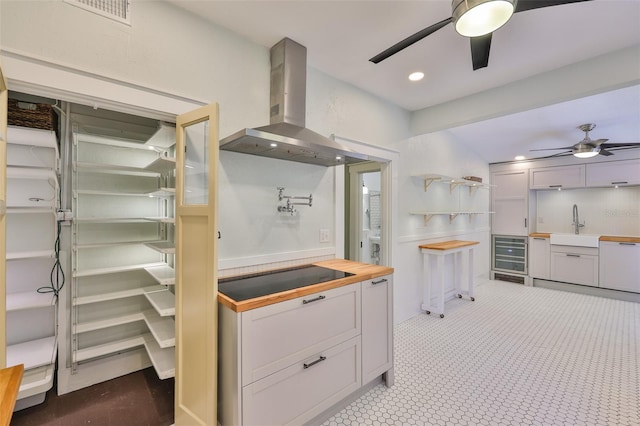 1825 2nd St S, Saint Petersburg, FL 33705 - kitchen featuring wall chimney range hood, ceiling fan, black electric stovetop, wine cooler, and recessed lighting