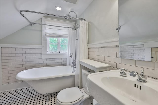 1825 2nd St S, Saint Petersburg, FL 33705 - full bathroom featuring tile walls, a sink, toilet, and vaulted ceiling