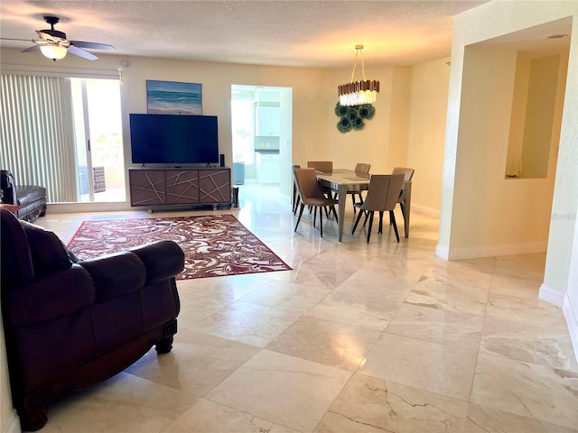 1180 Gulf Blvd Unit 306, Clearwater, FL 33767 - living area with a ceiling fan, baseboards, a chandelier, a textured ceiling, and light marble finish floors