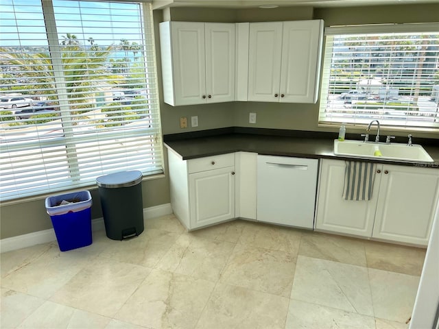 1180 Gulf Blvd Unit 306, Clearwater, FL 33767 - kitchen with a sink, dishwasher, baseboards, and dark countertops