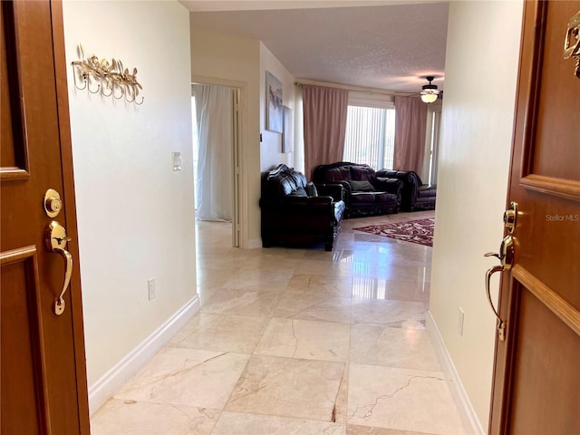 1180 Gulf Blvd Unit 306, Clearwater, FL 33767 - entryway featuring light marble finish floors, baseboards, ceiling fan, and a textured ceiling