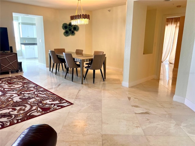 1180 Gulf Blvd Unit 306, Clearwater, FL 33767 - dining area with baseboards, a chandelier, and light marble finish floors