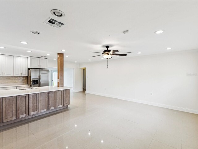 2016 Cove Dr, Largo, FL 33774 - kitchen featuring stainless steel fridge, light countertops, baseboards, white cabinetry, and recessed lighting