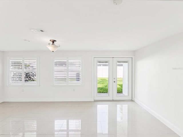 2016 Cove Dr, Largo, FL 33774 - unfurnished room featuring baseboards, light tile patterned floors, and french doors
