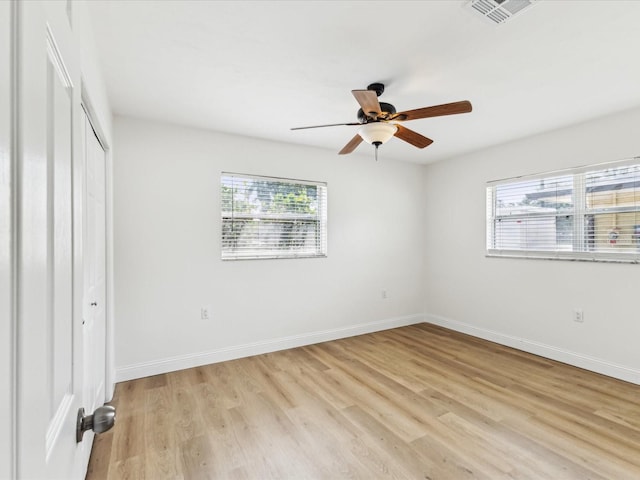 2016 Cove Dr, Largo, FL 33774 - unfurnished bedroom featuring multiple windows, light wood-type flooring, baseboards, and a closet