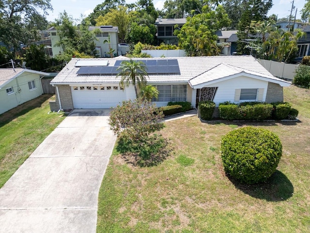 1598 Brookside Blvd, Largo, FL 33770 - ranch-style house with a tile roof, solar panels, driveway, and an attached garage