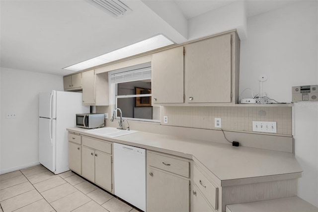 1598 Brookside Blvd, Largo, FL 33770 - kitchen with white appliances, a sink, light countertops, light tile patterned floors, and tasteful backsplash