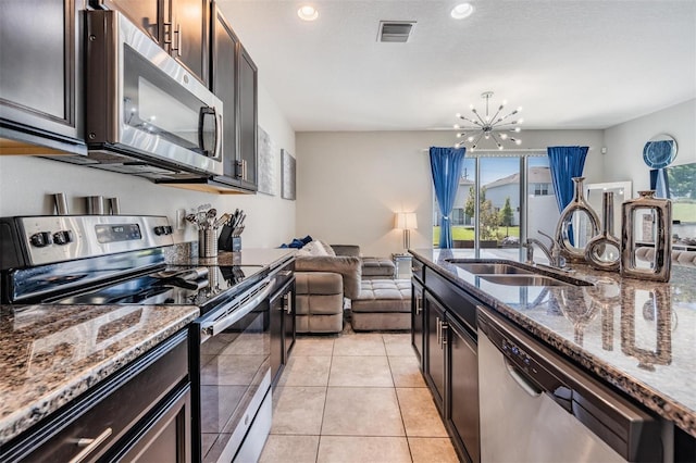 7030 Summer Holly Pl, Riverview, FL 33578 - kitchen featuring stainless steel appliances, a sink, open floor plan, a chandelier, and dark stone countertops