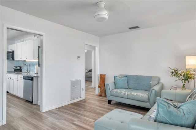 1117 Tyrone Blvd N, Saint Petersburg, FL 33710 - living area featuring light wood-style floors, baseboards, and ceiling fan