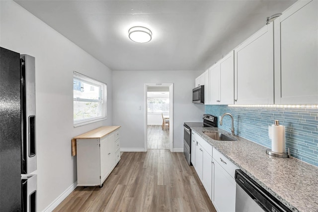1117 Tyrone Blvd N, Saint Petersburg, FL 33710 - kitchen with appliances with stainless steel finishes, a sink, light wood-style floors, and baseboards