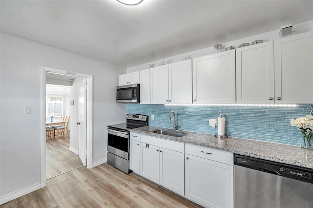 1117 Tyrone Blvd N, Saint Petersburg, FL 33710 - kitchen featuring appliances with stainless steel finishes, a sink, tasteful backsplash, and light wood finished floors