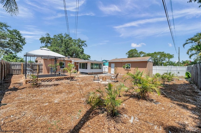 1117 Tyrone Blvd N, Saint Petersburg, FL 33710 - back of property featuring a gazebo, a fenced backyard, and stucco siding