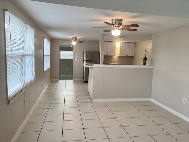 10367 109th Ave, Largo, FL 33773 - kitchen with fridge, a peninsula, light countertops, ceiling fan, and light tile patterned flooring
