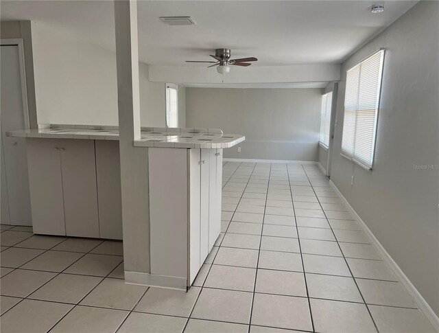 10367 109th Ave, Largo, FL 33773 - kitchen featuring tile counters, light tile patterned flooring, a ceiling fan, and baseboards