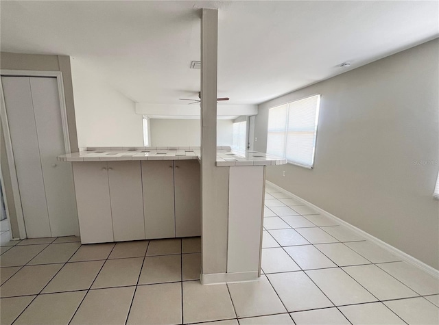 10367 109th Ave, Largo, FL 33773 - kitchen with tile countertops, light tile patterned floors, ceiling fan, and baseboards