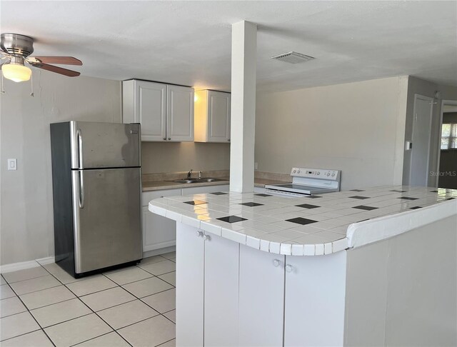 10367 109th Ave, Largo, FL 33773 - kitchen featuring freestanding refrigerator, electric stove, a sink, tile counters, and light tile patterned floors