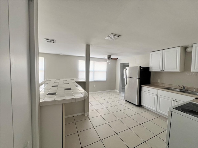 10367 109th Ave, Largo, FL 33773 - kitchen with tile counters, a sink, white electric range oven, white cabinetry, and freestanding refrigerator
