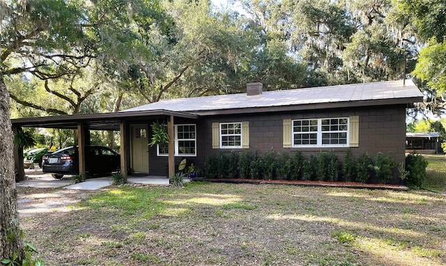 2748 Crk 543, Sumterville, FL 33585 - view of front of house featuring concrete block siding, a carport, metal roof, and a chimney