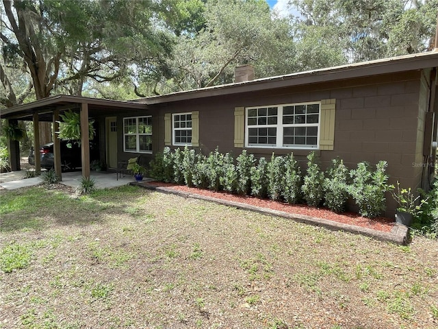 2748 Crk 543, Sumterville, FL 33585 - ranch-style house with concrete block siding, a chimney, and a patio area
