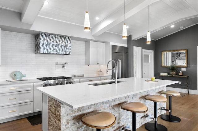 4649 Neptune Dr SE, Saint Petersburg, FL 33705 - kitchen featuring high end refrigerator, a sink, dark wood-style floors, decorative backsplash, and a kitchen bar