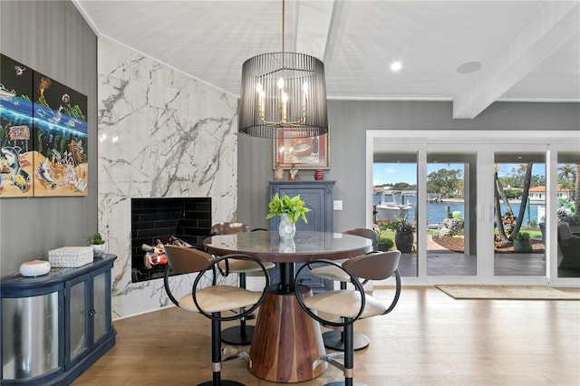 4649 Neptune Dr SE, Saint Petersburg, FL 33705 - dining area featuring wood finished floors, a water view, a premium fireplace, beamed ceiling, and recessed lighting