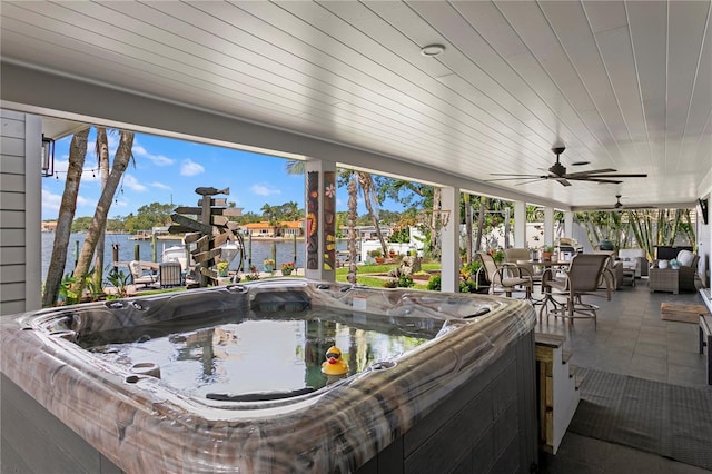 4649 Neptune Dr SE, Saint Petersburg, FL 33705 - view of patio / terrace featuring a hot tub, a water view, a ceiling fan, and outdoor dining space
