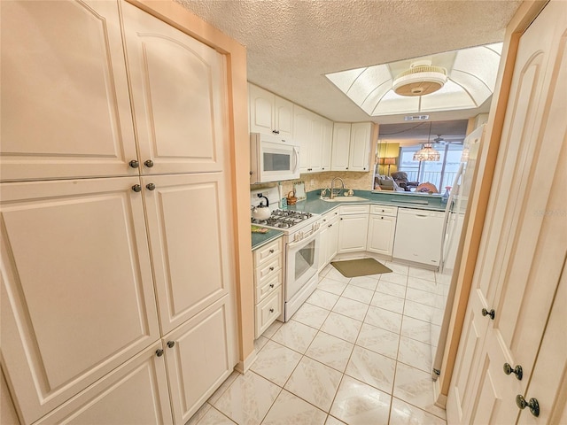 6060 Shore Dr S Unit 906, Gulfport, FL 33707 - kitchen with white appliances, light tile patterned flooring, a textured ceiling, dark countertops, and a sink